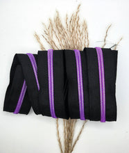 Laden Sie das Bild in den Galerie-Viewer, Endlosreißverschluss Schwarz Lila für #5-Zipper mit 6,5 mm Raupenbreite – Gesamtansicht, schwarzes Band mit lilafarbener Raupe.