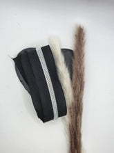 Laden Sie das Bild in den Galerie-Viewer, Endlosreißverschluss Schwarz Silber für #5-Zipper, 6,5 mm Raupenbreite – schwarzes Band mit silberfarbener Raupe, dekorativ auf einem Herz mit Trockenblumen fotografiert.