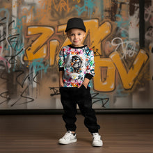 Laden Sie das Bild in den Galerie-Viewer, French Terry Panel Graffiti Pinguin Grau – Grauer Pinguin vor buntem Graffiti. Kleidungs-Mockup: Junge mit Kappe im Oberteil.
