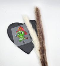 Laden Sie das Bild in den Galerie-Viewer, Größenlabel Bügelbild Feuerwehr Drache von Schnubbirella mit Beispielgröße 62 – einen grünen Drachen mit rotem Feuerwehrhelm, auf Trägerfolie vor schwarzem Dekoherz.
