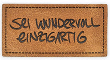 Laden Sie das Bild in den Galerie-Viewer, Detailaufnahme eines hochwertigen geprägten Kunstlederlabels „Sei wundervoll einzigartig“ für DIY- und Handmade-Projekte.