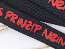 Laden Sie das Bild in den Galerie-Viewer, Baumwoll-Webband „Aus Prinzip nein“, 12 mm breit – schwarz mit rotem schriftzug, Nahaufnahme von Schrift und Gewebe.
