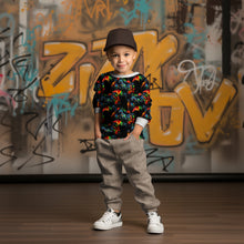 Laden Sie das Bild in den Galerie-Viewer, Baumwolljersey Gaming Colour Splash – 54596 – Bunte Gaming-Motive auf Schwarz. Kleidungs-Mockup: Junge mit Kappe im Oberteil.
