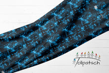Laden Sie das Bild in den Galerie-Viewer, French Terry Blue Crack – 52503 F – Leuchtend blaue Risse auf Schwarz. Drapierte Stoffbahn.
