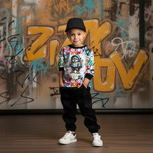 Laden Sie das Bild in den Galerie-Viewer, French Terry Panel Graffiti Pinguin Blau – Blauer Pinguin vor buntem Graffiti. Kleidungs-Mockup: Junge mit Kappe im Oberteil.
