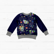 Laden Sie das Bild in den Galerie-Viewer, French Terry Pixelwelt Sternennacht – Bunte Pixelwelten vor Sternenhimmel. Kleidungs-Mockup: Flach ausgelegter Pullover.

