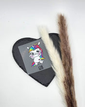 Laden Sie das Bild in den Galerie-Viewer, Größenlabel Bügelbild Funny Einhorn 2 von Schnubbirella mit Beispielgröße 128 – ein weißes Einhorn mit bunter Mähne, auf Trägerfolie vor schwarzem Dekoherz.
