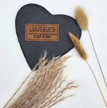 Laden Sie das Bild in den Galerie-Viewer, Braunes geprägtes Kunstlederlabel „Luusbueb – fräch &amp; luut“ in Schweizerdeutsch für Hoodies, Taschen und Kindermode.
